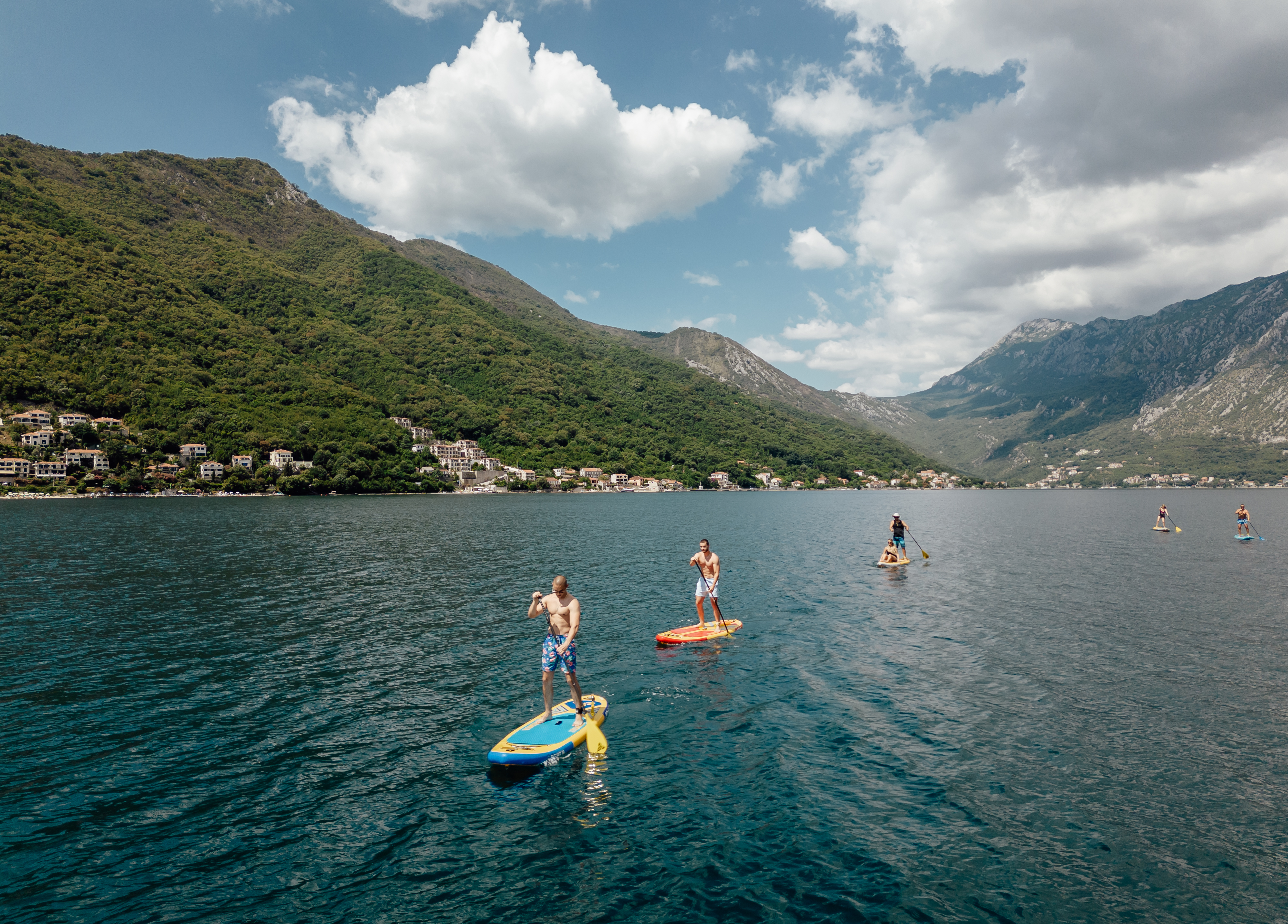 Drone view of group paddling across the Bay of Kotor