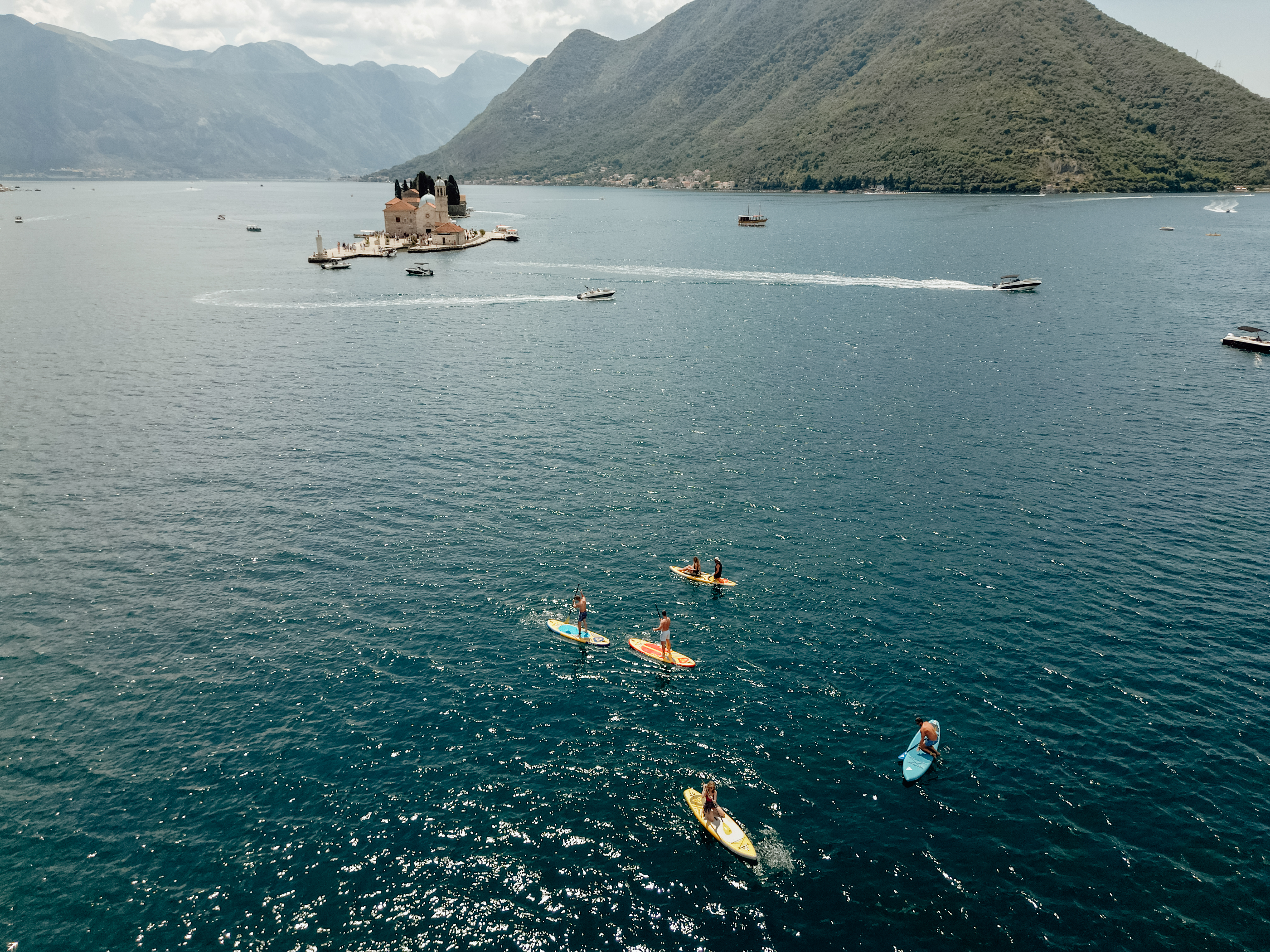 Drone view of paddleboarders near Our Lady of the Rocks island