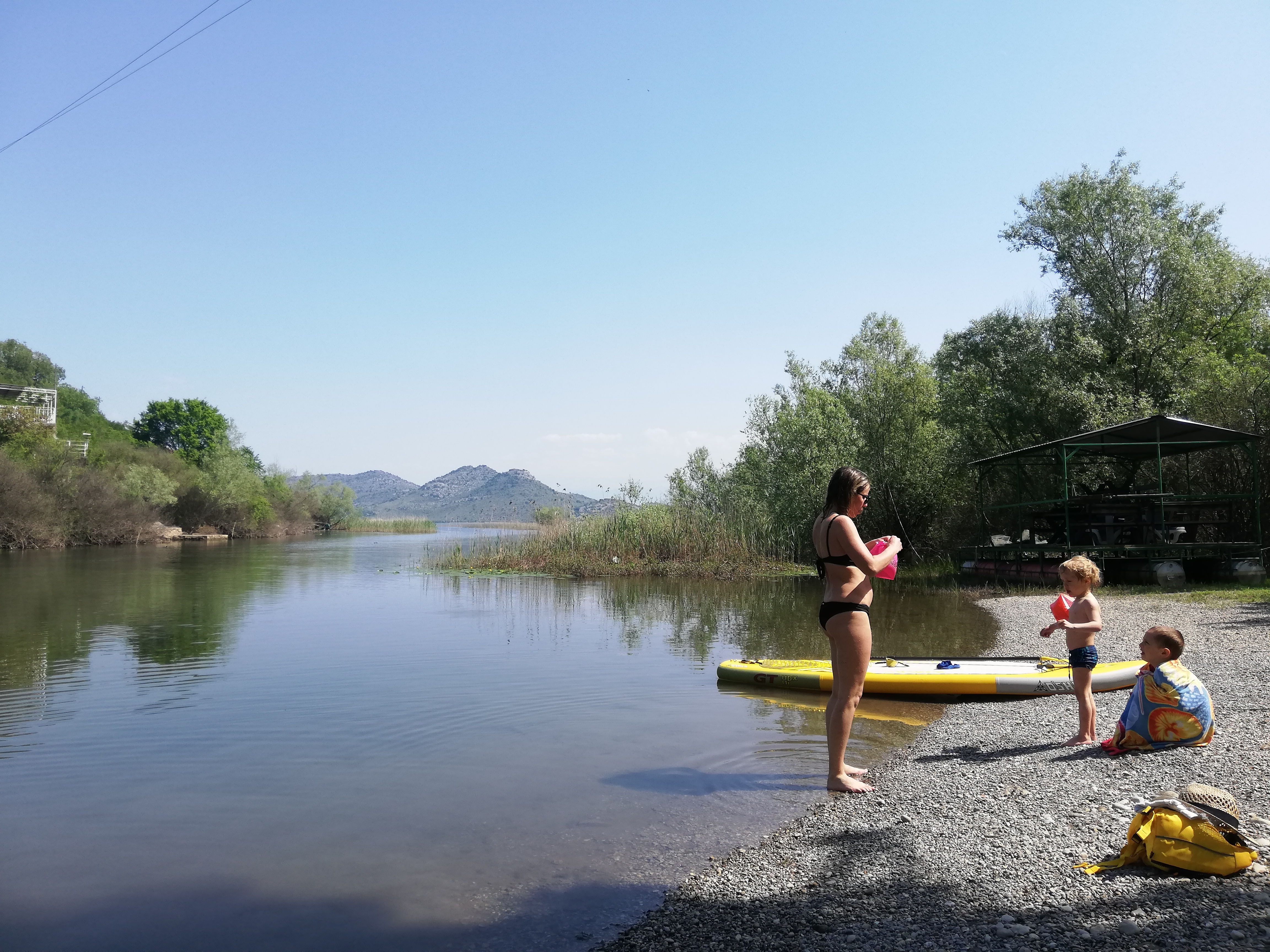 Mother and child at the lake shore with a SUP board